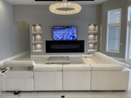 Shire lower-level lounge with white sectional and media wall