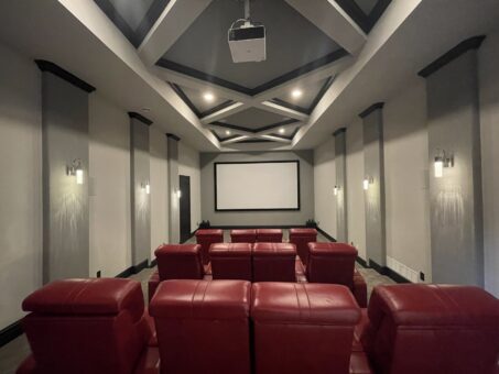 Kingfogl custom home lower-level home theater with red recliners and coffered ceiling