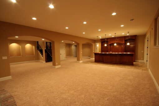 Kingfogl custom home lower level with arched openings and wood bar