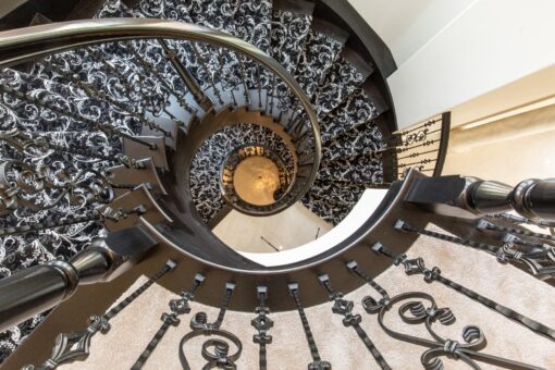 Shire spiral staircase with iron railing viewed from below