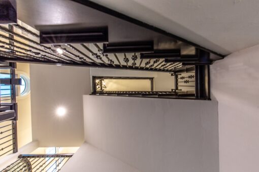 Kingfogl custom home staircase railing with iron balusters viewed from below