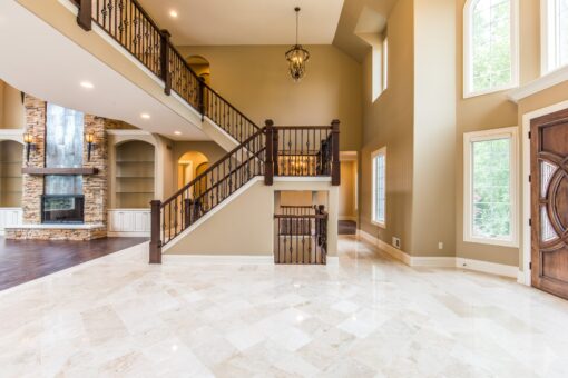 Kingfogl custom home switchback staircase with iron railing in a two-story foyer