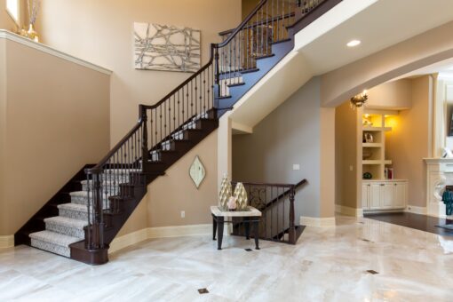Kingfogl custom home curved staircase with dark wood rail and iron balusters