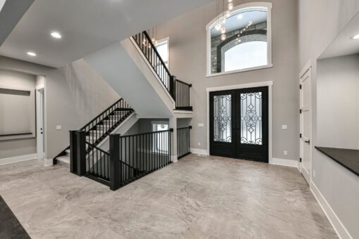 Hawks Ridge foyer with black staircase railing and arched entry doors