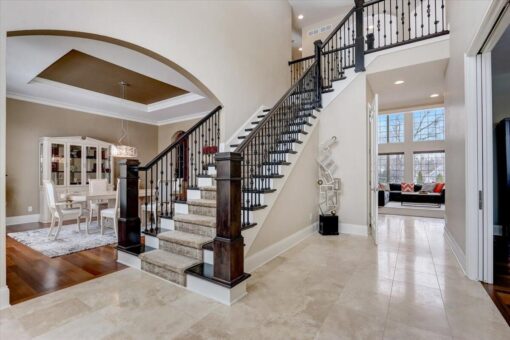 Ridgeview foyer staircase with iron railing and arched opening