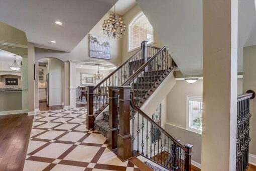 Talon foyer staircase with iron railing and patterned floor