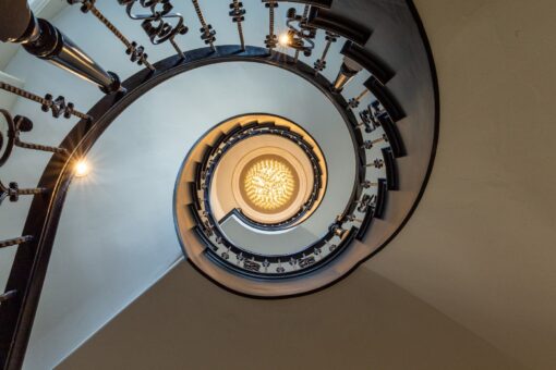 Kingfogl custom home spiral staircase viewed from below with iron railing