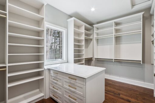 Rangeline walk-in closet with white built-ins and island