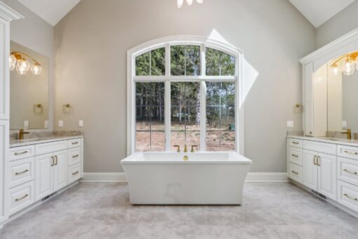 Rangeline primary bath freestanding tub beneath an arched window