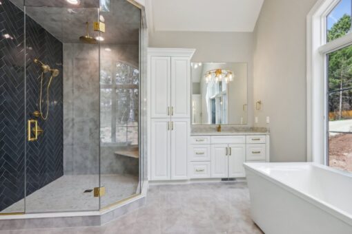 Rangeline primary bath shower with black tile and brass fixtures