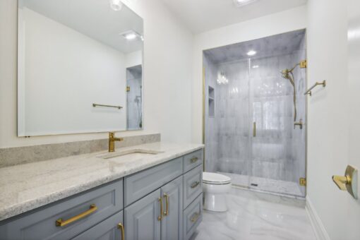 Rangeline bathroom with gray vanity and marble shower