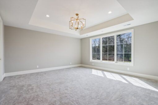 Rangeline lower-level room with tray ceiling and chandelier