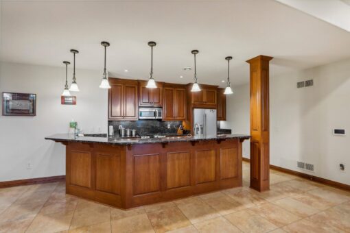 Danbury lower-level kitchen with wood island and pendant lights