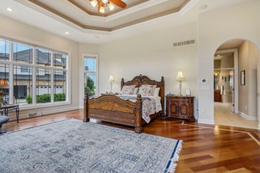Danbury bedroom with hardwood floors and carved wood bed