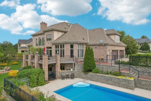 Danbury pool and patio below the brick rear elevation
