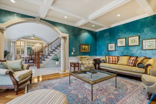 Danbury living room with teal walls and view to the staircase