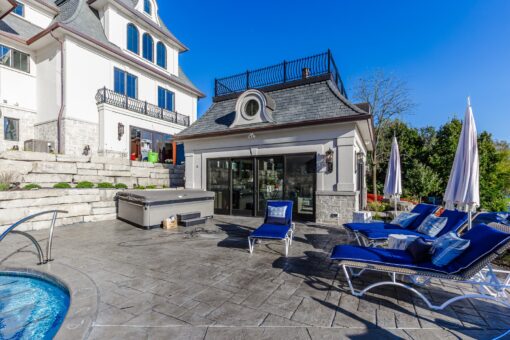 Gatsby pool deck with lounge chairs and stone retaining walls