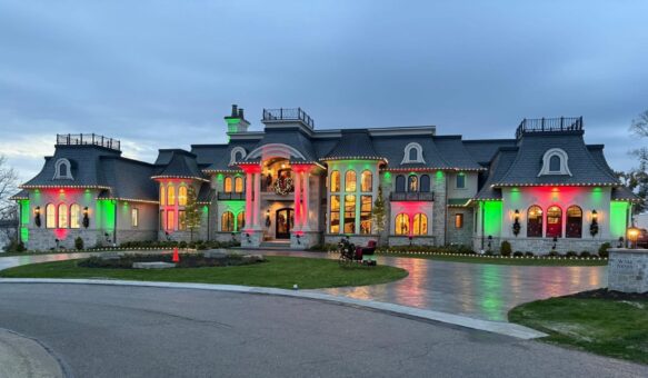 Gatsby custom estate front elevation and circular drive lit up at dusk