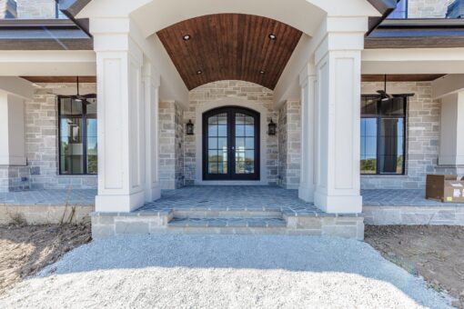 Ridge front entry portico with wood ceiling and arched doors