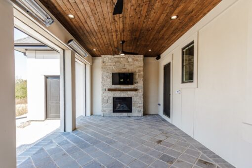 Ridge covered patio with stone fireplace and wood ceiling