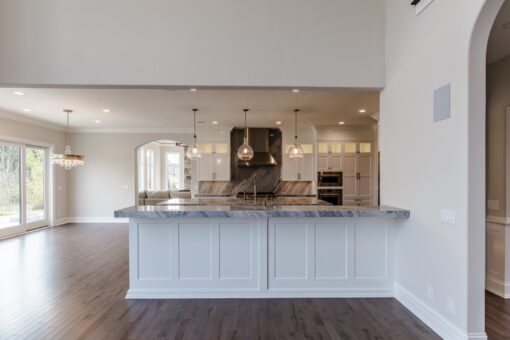 Settlers Circle kitchen island with white cabinetry and range wall