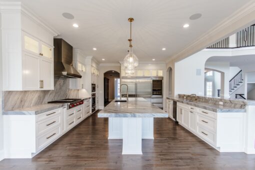Settlers Circle white kitchen with marble island and pendant lights
