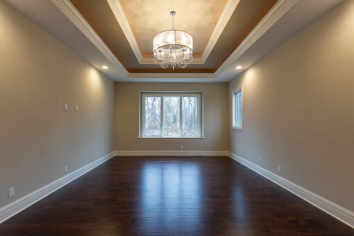 Woodview bedroom with tray ceiling and chandelier