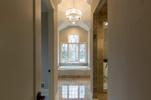 Woodview primary bath tub alcove with chandelier