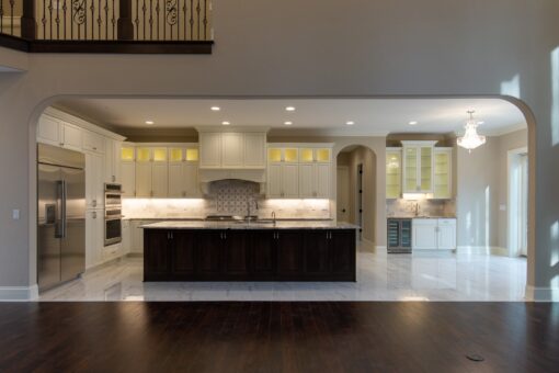 Woodview kitchen with dark island and lit glass cabinetry
