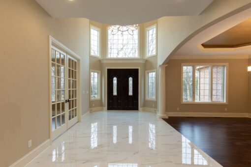 Woodview foyer with entry doors and arched windows