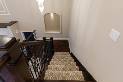 Woodview staircase with carpet runner and iron railing