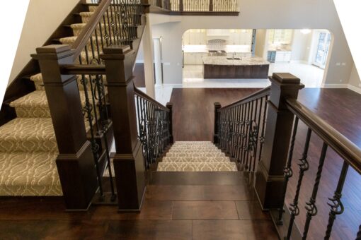 Woodview staircase with iron railing and view to the kitchen