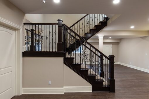 Woodview lower-level staircase with iron railing