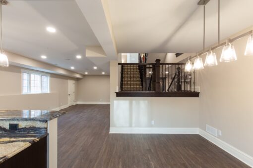 Woodview lower level with staircase and pendant lights