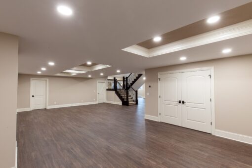 Woodview lower-level room with tray ceiling and staircase