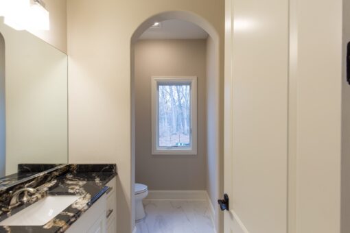 Woodview bathroom with arched doorway and black granite vanity