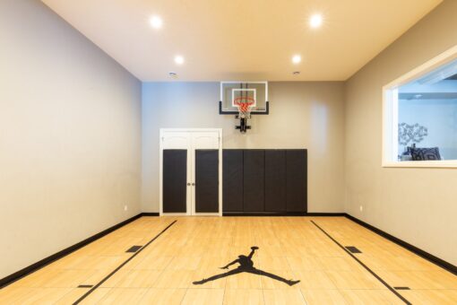 Kingfogl custom home indoor basketball court with hoop and wood floor