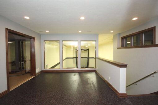 Kingfogl custom home home gym with rubber flooring and glass doors