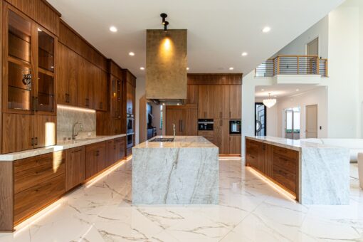 Carlisle kitchen with marble waterfall island and brass range hood