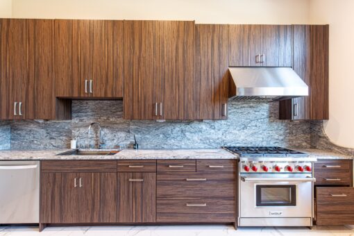 Carlisle kitchen range wall with walnut cabinetry and mosaic backsplash