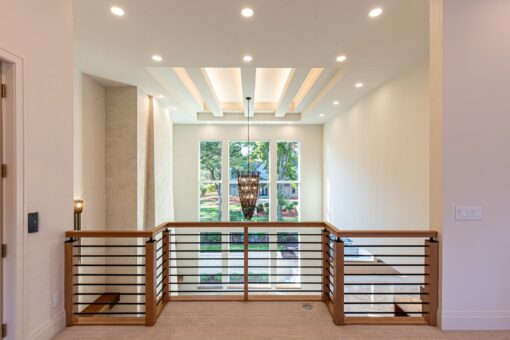 Carlisle loft with metal railing and lit tray ceiling