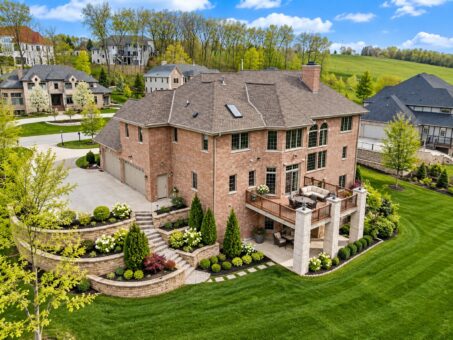 Benington custom home in Brookfield by Kingfogl – rear elevation with terraced stone landscaping