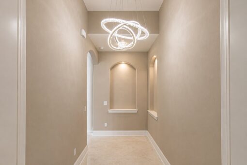 Saddlebrook custom home in Mequon by Kingfogl – hallway with ring chandelier