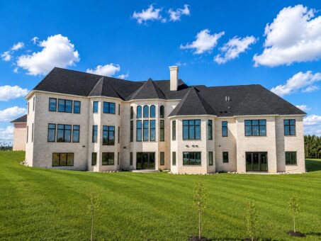 Saddlebrook custom home in Mequon by Kingfogl – rear elevation with cream brick and walls of windows