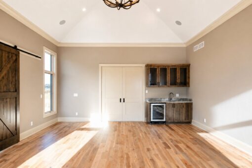 Sanctuary custom home in Menomonee Falls by Kingfogl – hearth room barn door and wet bar