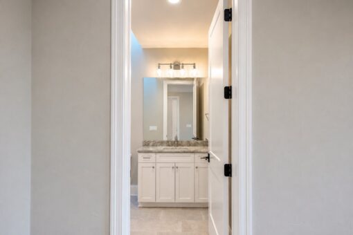 Sanctuary custom home in Menomonee Falls by Kingfogl – basement bathroom vanity through doorway
