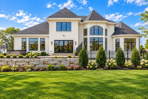 Settlers Circle custom home in Sheboygan Falls by Kingfogl – rear elevation with arched windows and stone wall