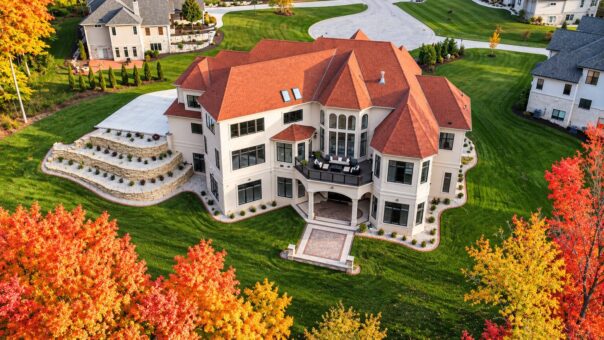 Shire custom home in Brookfield by Kingfogl – aerial rear view with terraced patios and fall color