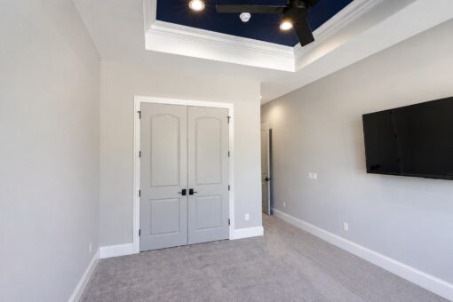 Apex bedroom with navy tray ceiling and double doors