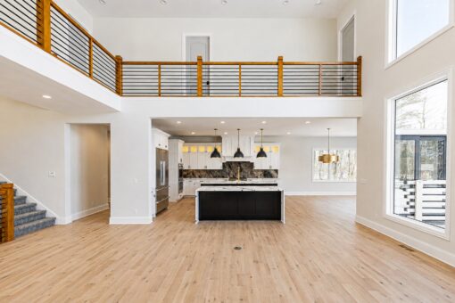 Apex great room beneath the balcony with view to the kitchen